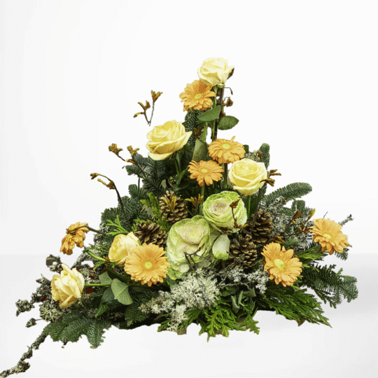 Höstinspirerad sorgdekoration med ljusgula rosor, aprikos gerbera och kottar – en naturlig och varm hyllning vid begravning.
