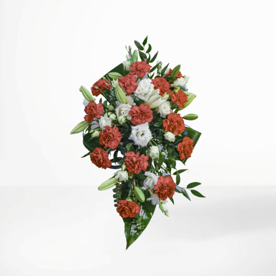 Sorgdekoration med röda nejlikor och vita liljor samt gröna blad – en symbol för kärlek och frid vid begravning.