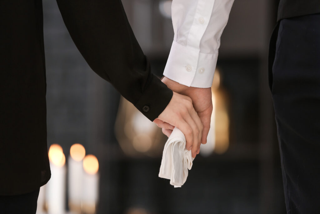 Par som håller händer på en begravning