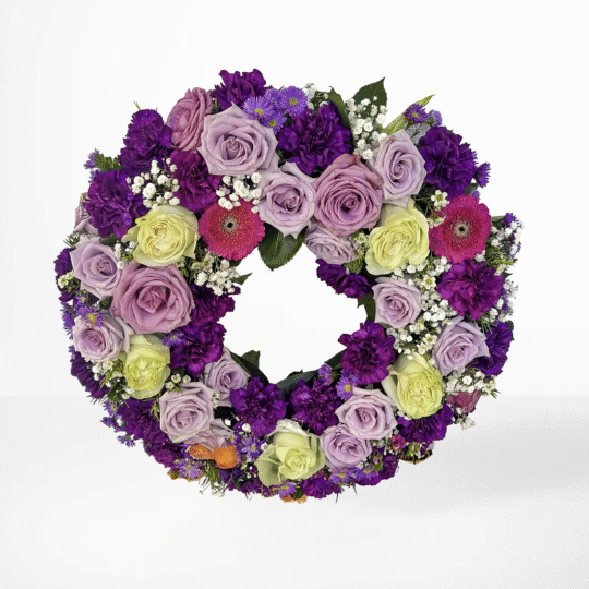 Begravningskrans med rosa och lila rosor samt mörklila nejlikor – en värdig symbol för evighet och omtanke.
